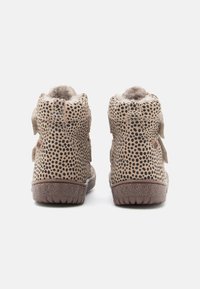 Braune High-Top-Schuhe mit einem gepunkteten Muster, weicher Innenausstattung und Klettverschlüssen. Strukturierte Gummisohle mit Grip für zusätzlichen Halt.