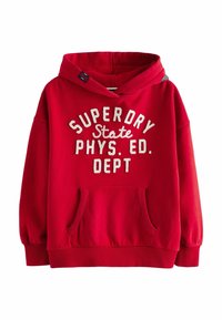 Röd bomullshuvtröja med framficka, elastiska muddar och vit text: "SUPERDRY State PHYS. ED. DEPT." i fet, krökt stil.