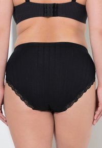 Zwarte high-waisted broek met kantafwerking, met een gestructureerd patroon en een gladde afwerking. De achterkant toont de haak-en-oog sluiting.