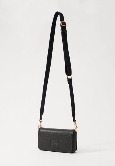 Czarna skórzana torba na ramię o teksturowym wykończeniu, ze złotymi akcentami i czarnym paskiem z wzorem logo. Kompaktowy prostokątny kształt.