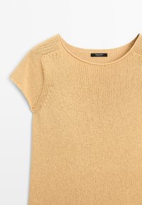 Beige short-sleeve knit top with round neckline and fine stitching, lying flat on a white background.