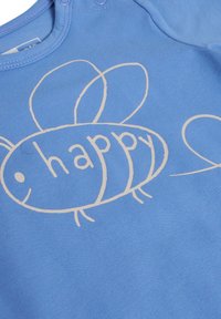 Ljusblått tygbody med en enkel vit bi-design där ordet "happy" är integrerat i kroppen. Mjuk textur, tryckknapps-stängning.