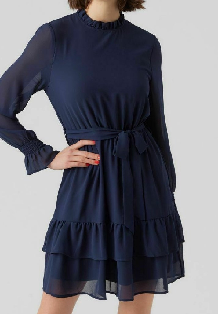 Robe bleu marine en tissu léger, avec un col montant, des manches longues, une ceinture nouée et des volants superposés au bas.