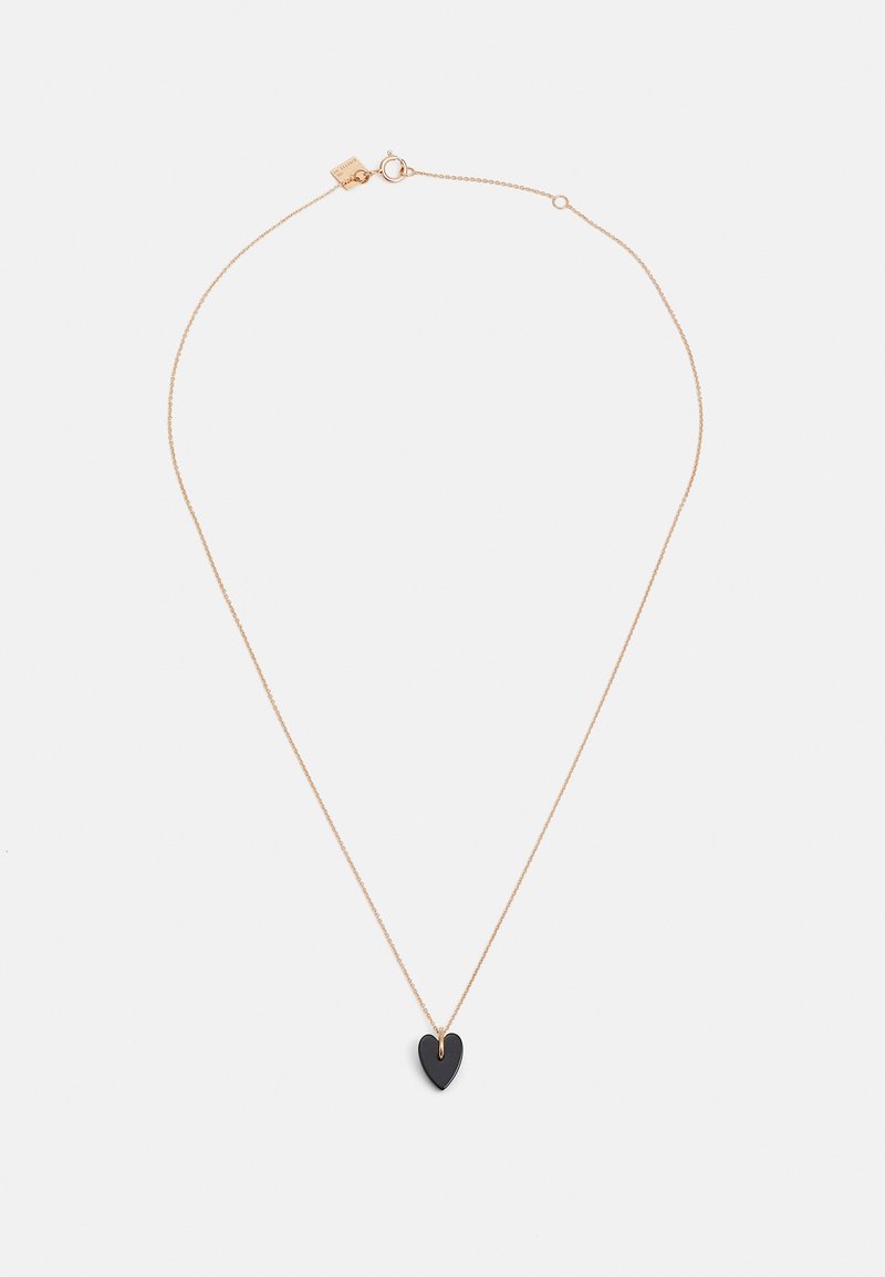 Collar de cadena en tono dorado que presenta un pequeño colgante en forma de corazón negro con una superficie lisa y una sección recortada en la parte superior para el engaste.