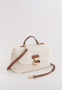 Bolso de mano de piel sintética blanca con una forma estructurada, detalles en cuero marrón, herrajes dorados y una correa desmontable. Cuenta con un cierre de solapa.