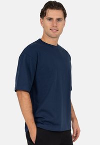 Marineblauw katoenen T-shirt met een ontspannen pasvorm, korte mouwen en een ronde hals. De stof oogt glad en lichtgewicht.