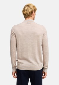 Hellbeige Pullover mit strukturiertem Strick, langen Ärmeln und Kragen, mit taillierter Passform und geripptem Saum sowie Bündchen.