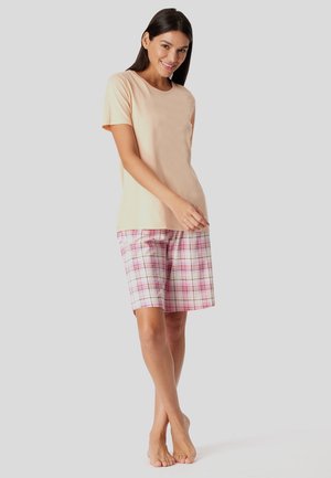 Hellbeige T-Shirt mit kurzen Ärmeln, kombiniert mit rosa karierter Shorts, die weiße und lila Linien aufweist. Das Outfit besteht aus weichem Stoff.