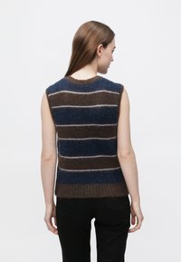 Bezrukávový sveter zo zmesi vlny s hnedými, modrými a bielymi vodorovnými pruhmi a rebrovanou štruktúrou na leme.