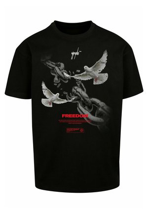 Mustmust valge t-särk, millel on graafika kahest valgest tuvist, kes purustavad ahelaid. Tekst sisaldab sõna "VABADUS" punases, koos täiendavate märkidega all.