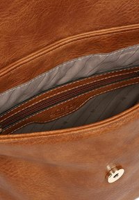 Braune Ledertasche mit grauem Innenfutter, ausgestattet mit einer Reißverschlusstasche und einem goldenen Druckknopfverschluss. Glatte Textur und minimale Nähte.