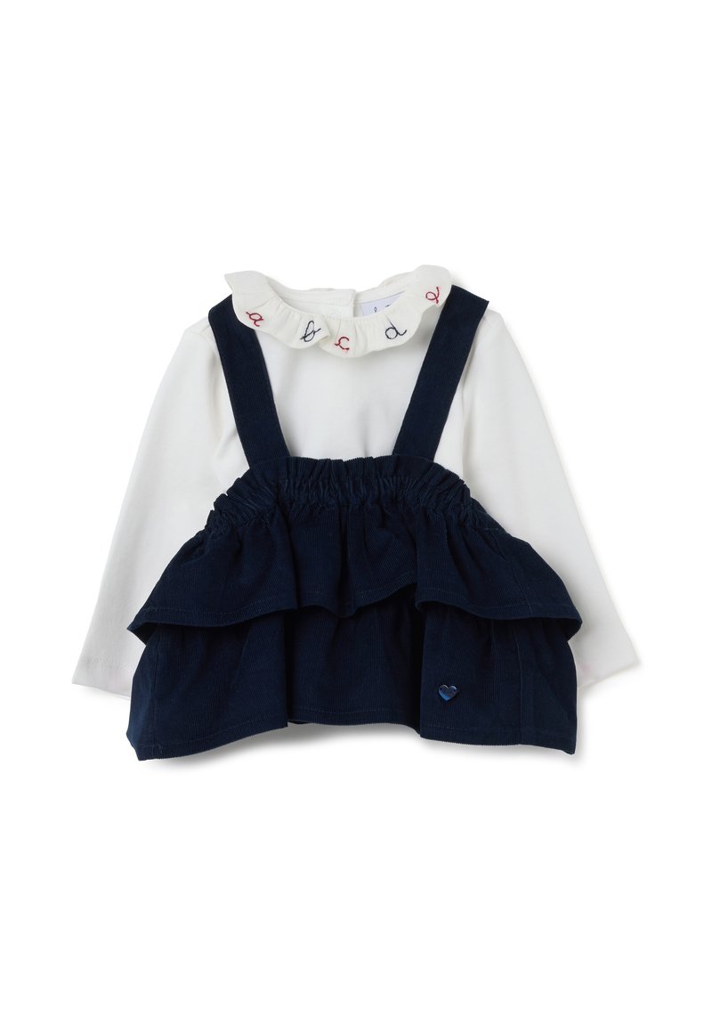 Maglietta bianca a maniche lunghe con collo arricciato e bretelle in velluto a coste blu navy con rouches sovrapposte. Piccolo cuore in rilievo sul davanti.
