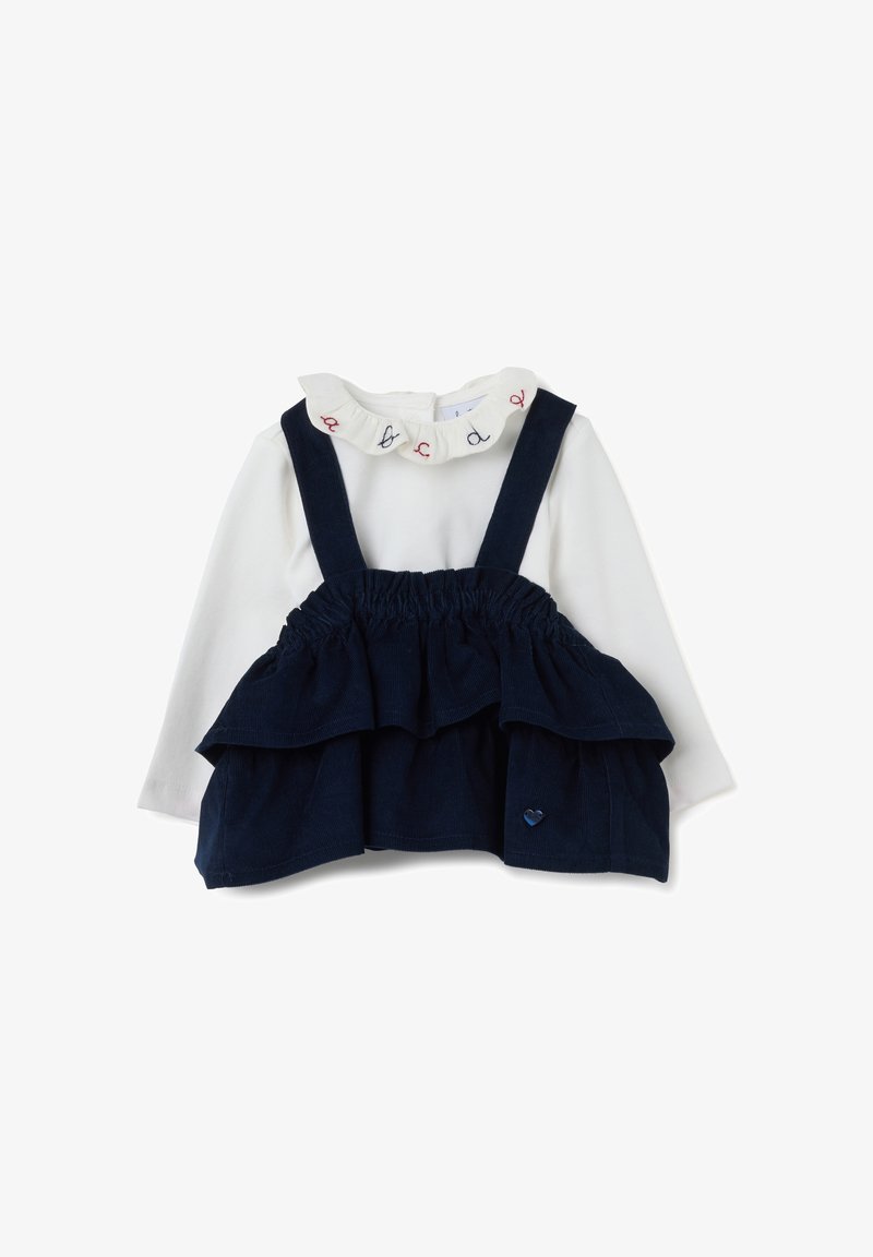 Maglietta bianca a maniche lunghe con collo arricciato e bretelle in velluto a coste blu navy con rouches sovrapposte. Piccolo cuore in rilievo sul davanti.