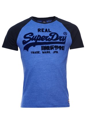 Blå og sort raglan-ærmet T-shirt med "Real SuperDry" og japanske tegn trykt i fed skrift på forsiden.