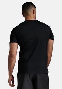 Svart kortärmad T-shirt i mjukt tyg, med en klassisk rund hals och avslappnad passform, utan synliga tryck eller mönster.