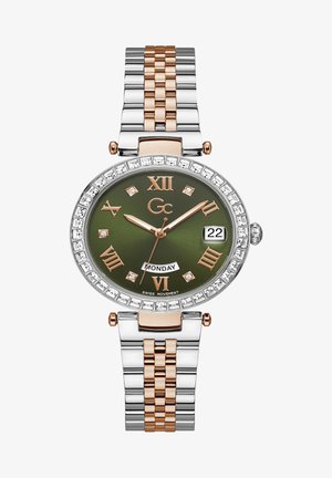 Guld- og sølvfarvet metal armbåndsur med grøn urskive, diamantdetaljer, romerske tal og datovisning. Har et tofarvet led armbånd.