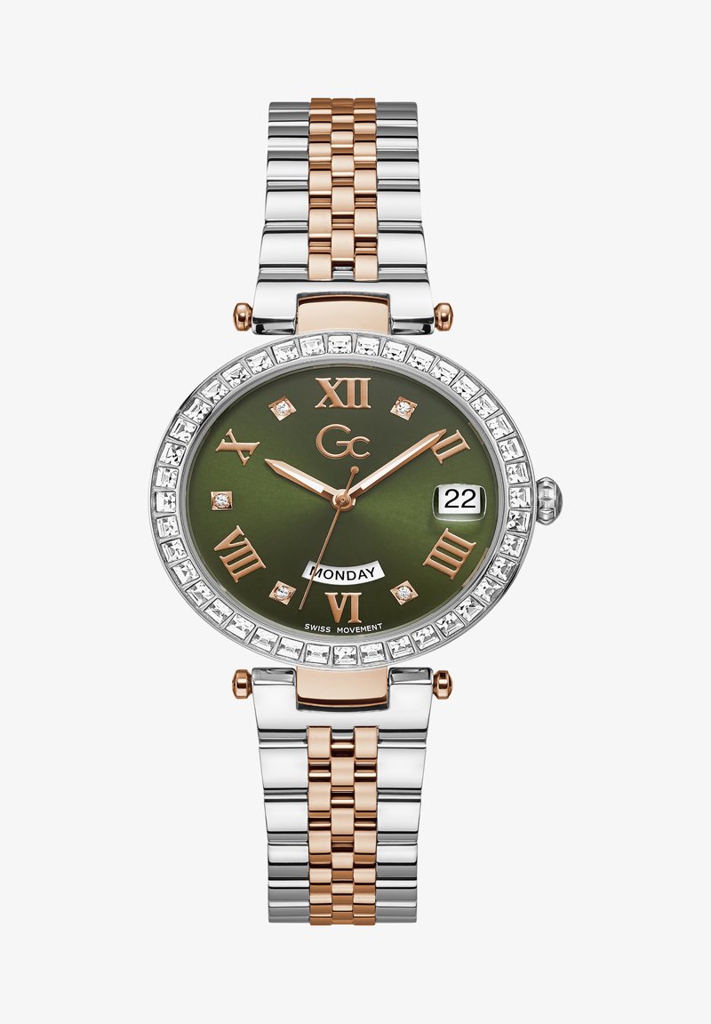 Guld- och silverfärgad metallarmbandsur med grön urtavla, diamanter, romerska siffror och datumvisning. Har ett tvåfärgat länkarmband.