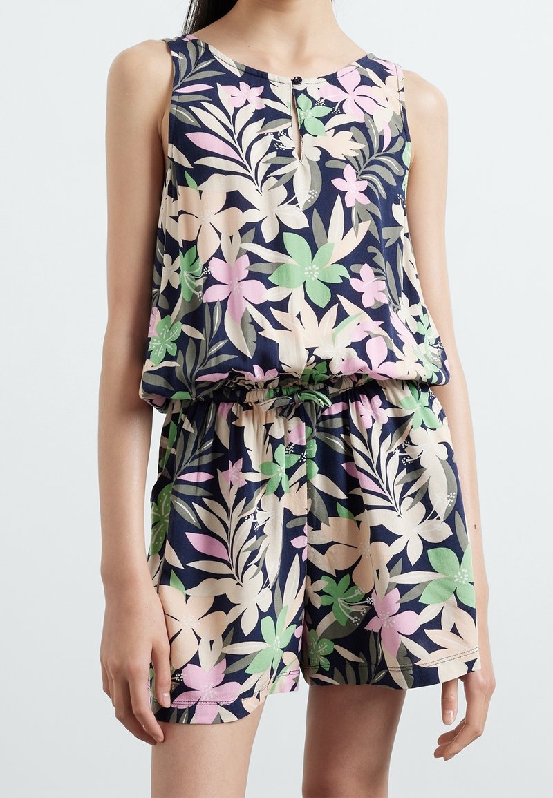 Combinaison sans manches bleu marine avec un motif floral en rose, vert et crème. Taille élastique et patte de boutonnage au niveau de l'encolure.