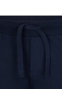 Pantaloni da tuta in cotone blu navy con vita piatta e stringa esterna, tessuto finemente lavorato e dettagli di cucitura.