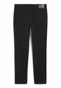 Pantalon extensible noir avec une coupe slim, deux poches arrière et une étiquette de ceinture mate. Texture lisse, coupe droite au niveau des jambes.
