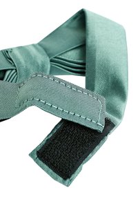 Tompa teal színű, texturált szövetből készült csokornyakkendő, gondosan megkötve, fekete tépőzárral a szabályozható illeszkedés érdekében.