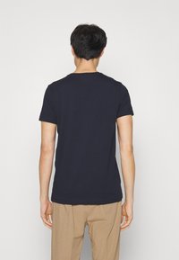 Marineblå kortærmet t-shirt lavet af bomuld. Har en rund halsudskæring og et enkelt design uden synlige logoer eller mønstre.