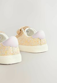 Baskets pastel pailletées avec un extérieur doré et rose tacheté, un tissu texturé et un onglet de talon lila lisse avec une semelle blanche.