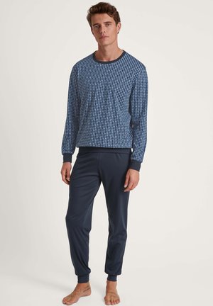 Haut à manches longues bleu marine avec un motif géométrique et un col rond, associé à un pantalon de jogging bleu marine uni avec des poignets élastiques.