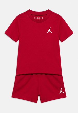 Conjunto de camiseta de manga corta roja y pantalones cortos con el logo Jumpman blanco en el pecho y en la pierna izquierda de los pantalones, diseñado para uso casual.