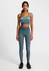 Zestaw sportowy: biustonosz i legginsy w kolorze morskim, z prążkowaną fakturą, bezszwowy, z wysokim pasem i białym wykończeniem wzdłuż boków.