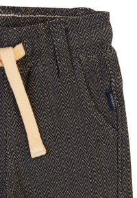Donker met herringbone-patroon broek met een elastische tailleband, voorzien van een beige trekkoord en een klein merkembleem aan de zijkant.