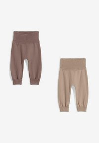 Deux paires de joggers en coton pour bébé : une brune avec une taille et des poignets côtelés, et une beige avec un design et des détails similaires.