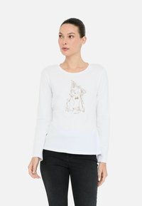 Tricou alb cu mânecă lungă, fabricat din bumbac moale, având un design cu iepure metalic auriu în centru, guler rotund și croială lejeră.