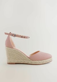 Pink leather wedge shoe with an ankle strap, textured surface, and a woven jute heel. Smooth toe and side openings.