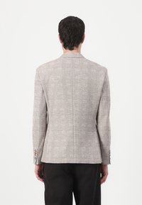 Texturiertes, hellgraues Blazer mit einem Karomuster, einzelner Schlitz und geknöpften Manschetten. Taillierte Passform mit strukturierten Schultern.