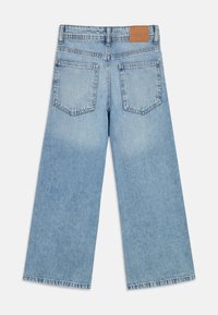 Hästi laiad teksad helesinisest denimist, tuhmunud efektiga, kahe tagataskuga ja vööjoonel kunstnahast plaastriga.