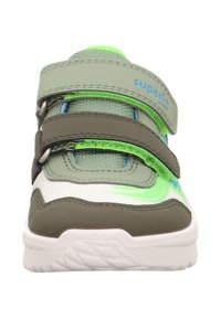 Grüne und weiße Sportschuhe mit Klettverschluss, Gummisohle, strukturiertem Stoff und blauen Akzenten. Sie verfügen über eine abgerundete Zehenpartie und eine robuste Bauweise.