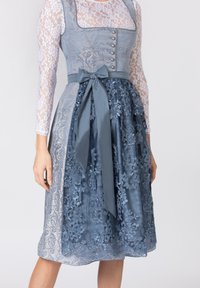 Blaues Kleid mit Spitze im Oberteil, Knopfdetails und floralem Stickmuster. Satinrock, mit einer Schleife gebunden. Textilstruktur kontrastiert mit glatten Akzenten.