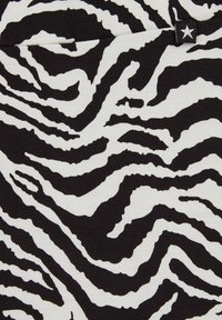 Zebras raksts audums izceļas ar drosmīgiem melnbaltiem svītrainiem un ribotu tekstūru; augšējā stūrī redzama neliela zvaigznes birka.