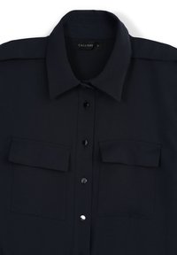 Chemise bleue marine à boutons avec deux poches poitrine, boutons noirs et col classique. Fabriquée en tissu lisse et léger. Taille S.