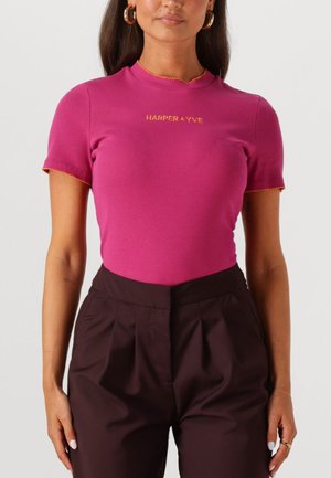 Fitted pink ribbed t-shirt with short sleeves and scalloped orange trim. Features "HARPER & YVE" embroidered on the front.