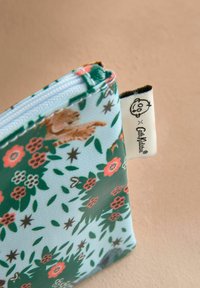 Zibiniekas gaiši zils ar ziedu un dzīvnieku rakstiem. Izgatavots no strukturēta materiāla, ar rozā un zaļiem akcentiem. Iekļauta birka.