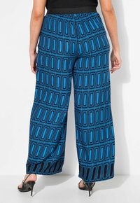 Kalhoty s širokými nohavicemi z modré látky s geometrickým černým a modrým vzorem. Elastický pas a strukturovaný povrch, s uvolněným střihem.