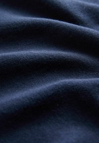 Tessuto blu scuro con una texture morbida e una leggera lucentezza, caratterizzato da onde morbide e fluide e un motivo di tessitura fine.