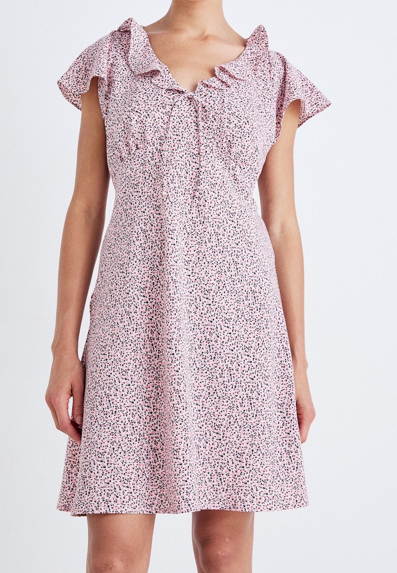 Kurzes pinkes Kleid mit einem gerafften Ausschnitt und kurzen Ärmeln, das ein verstreutes Muster aus schwarzen und pinken Punkten aufweist.