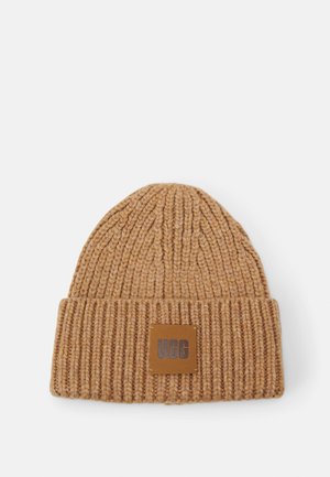 Bonnet en laine côtelée brun clair avec revers plié et patch carré en cuir affichant le logo « UGG » au centre devant.