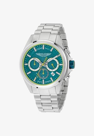 Montre en acier inoxydable argenté avec un cadran texturé vert sarcelle, des accents jaunes, trois sous-cadrans, un affichage de la date et une couronne bleue. Mécanisme alimenté par énergie solaire.