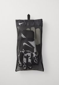 Nike målmandshandsker i en sort mesh taske. Handskerne har et geometrisk mønster i sort, hvid og grå, med en forstærket håndledsrem.