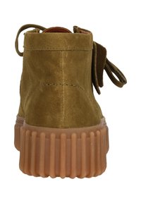 Bottines en daim vert olive avec des bouts arrondis et une semelle épaisse en caoutchouc translucide avec des nervures verticales. La vue arrière montre une étiquette en tissu.
