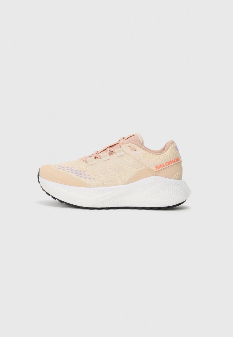 Baskets de course Salomon en rose clair et beige avec une semelle épaisse blanche et un profil noir, vue de côté sur fond blanc uni.